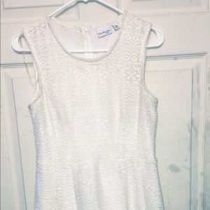 A white, lace designed child’s dress